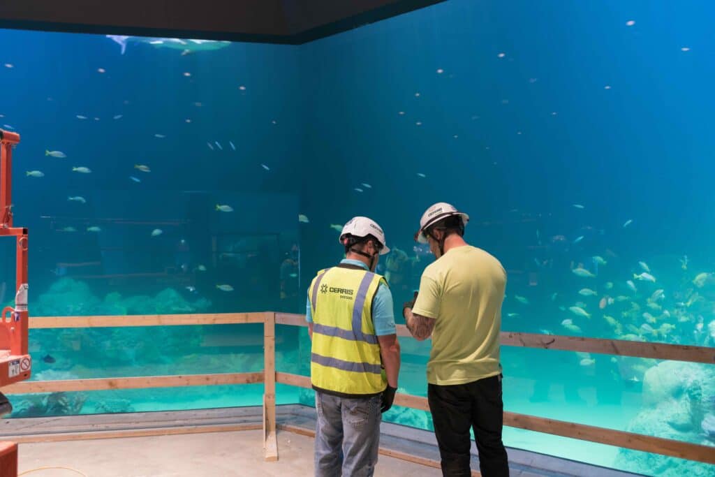 Mechanical workers in front of large tank in Kansas City aquarium. Mechanical workers in front of large tank in Kansas City aquarium.