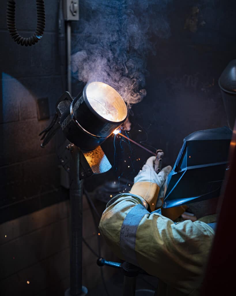 Welder practicing pipe welds at a union training center. Welder practicing pipe welds at a union training center.