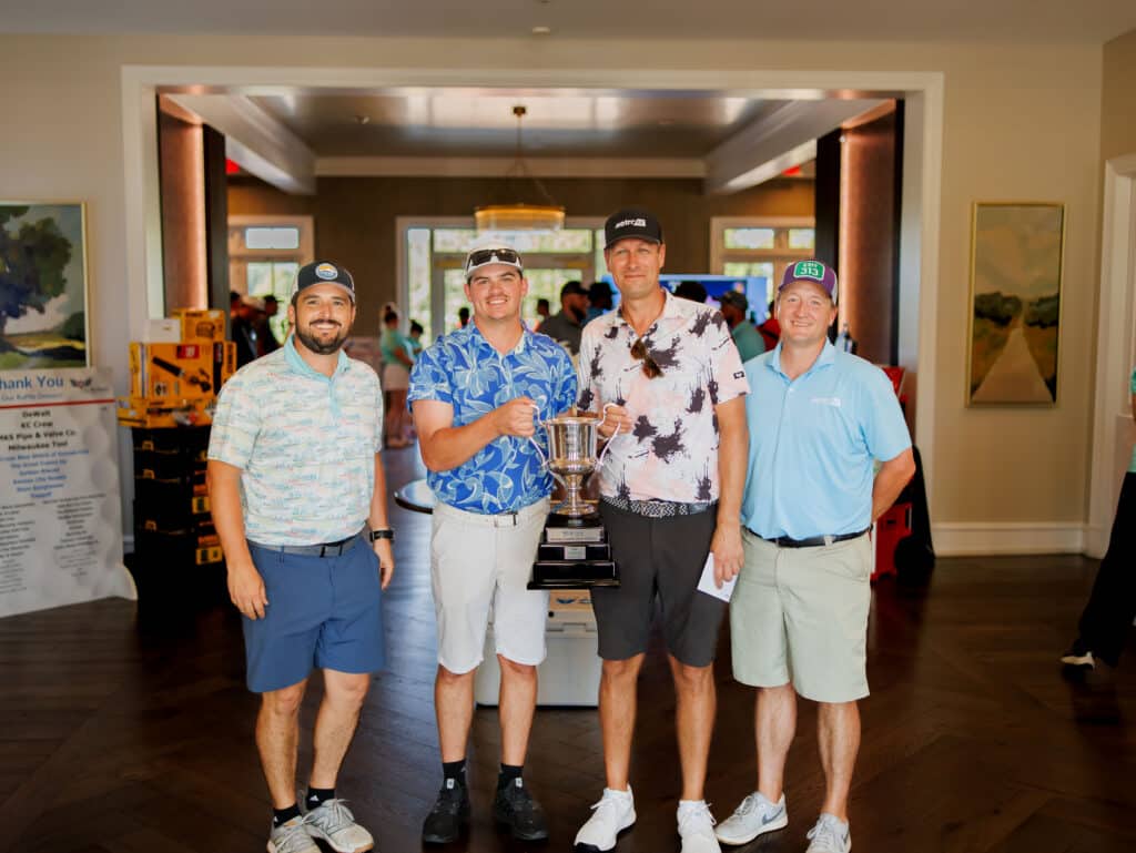The 2026 MCAKC Golf Outing champions, Metro Air, celebrate with the tournament trophy.