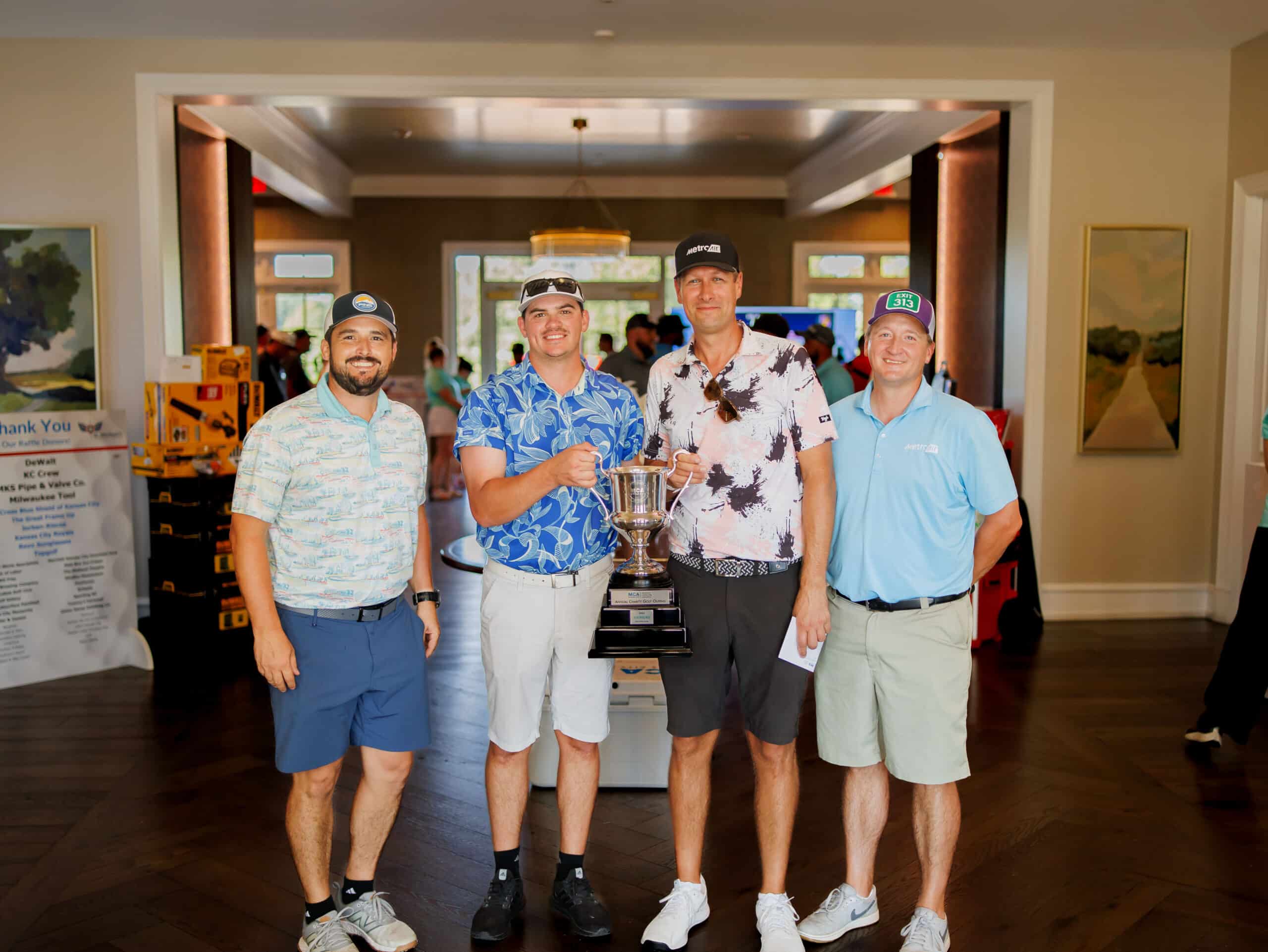 The 2026 MCAKC Golf Outing champions, Metro Air, celebrate with the tournament trophy.